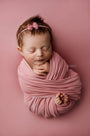 Chandler Pinkypie a pink newborn photography backdrop draped on a posing table or beanbag, that is a smooth, stretchy and soft fabric for beautiful baby portraits. Creidt Arielle Elizabeth Photography