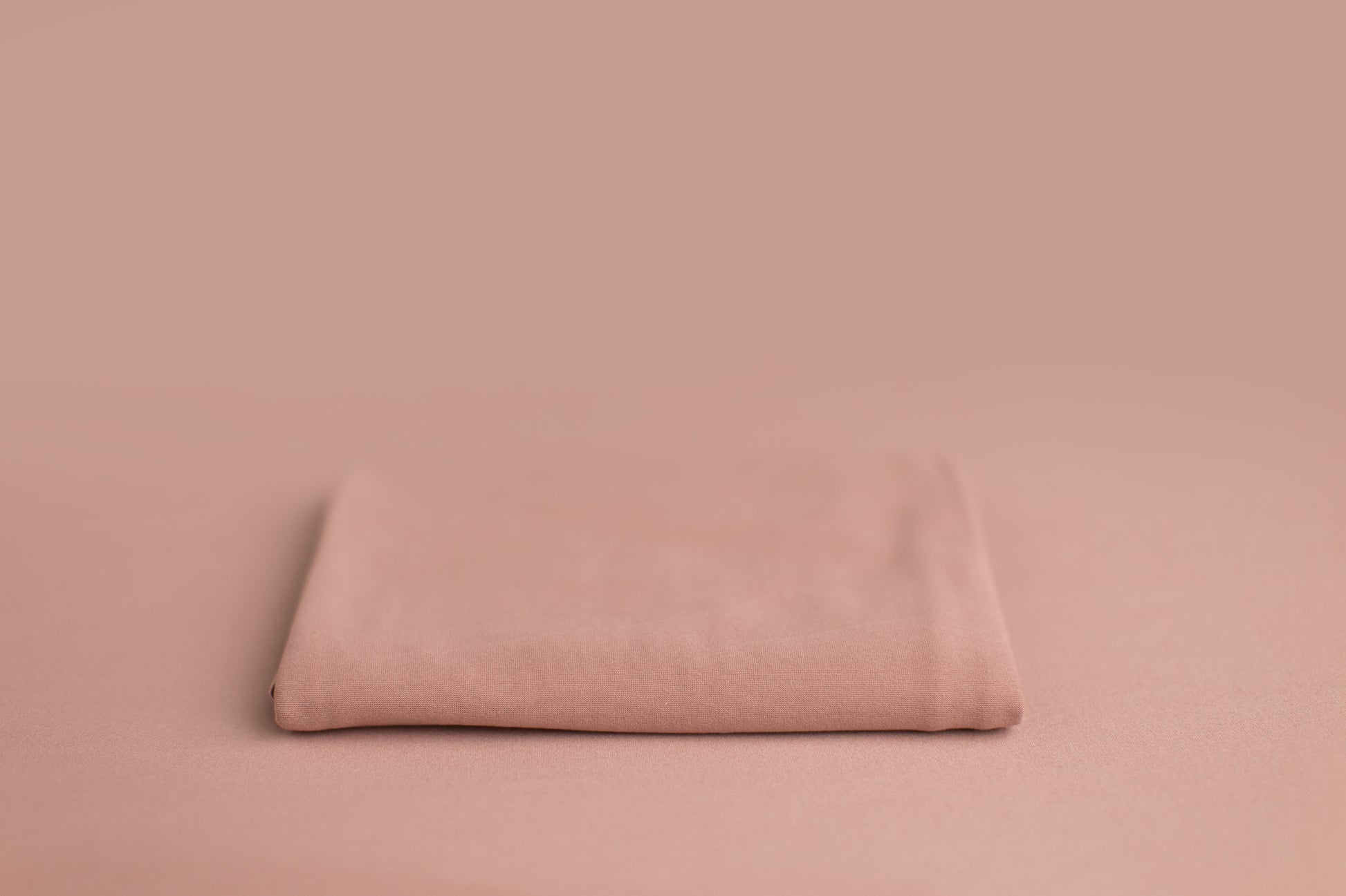 Chandler Love Potion a pink and purple newborn photography backdrop draped on a posing table or beanbag, that is a smooth, stretchy and soft fabric for beautiful baby portraits.