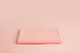 Chandler Shrimp a light pink newborn photography backdrop draped on a posing table or beanbag, that is a smooth, stretchy and soft fabric for beautiful baby portraits.